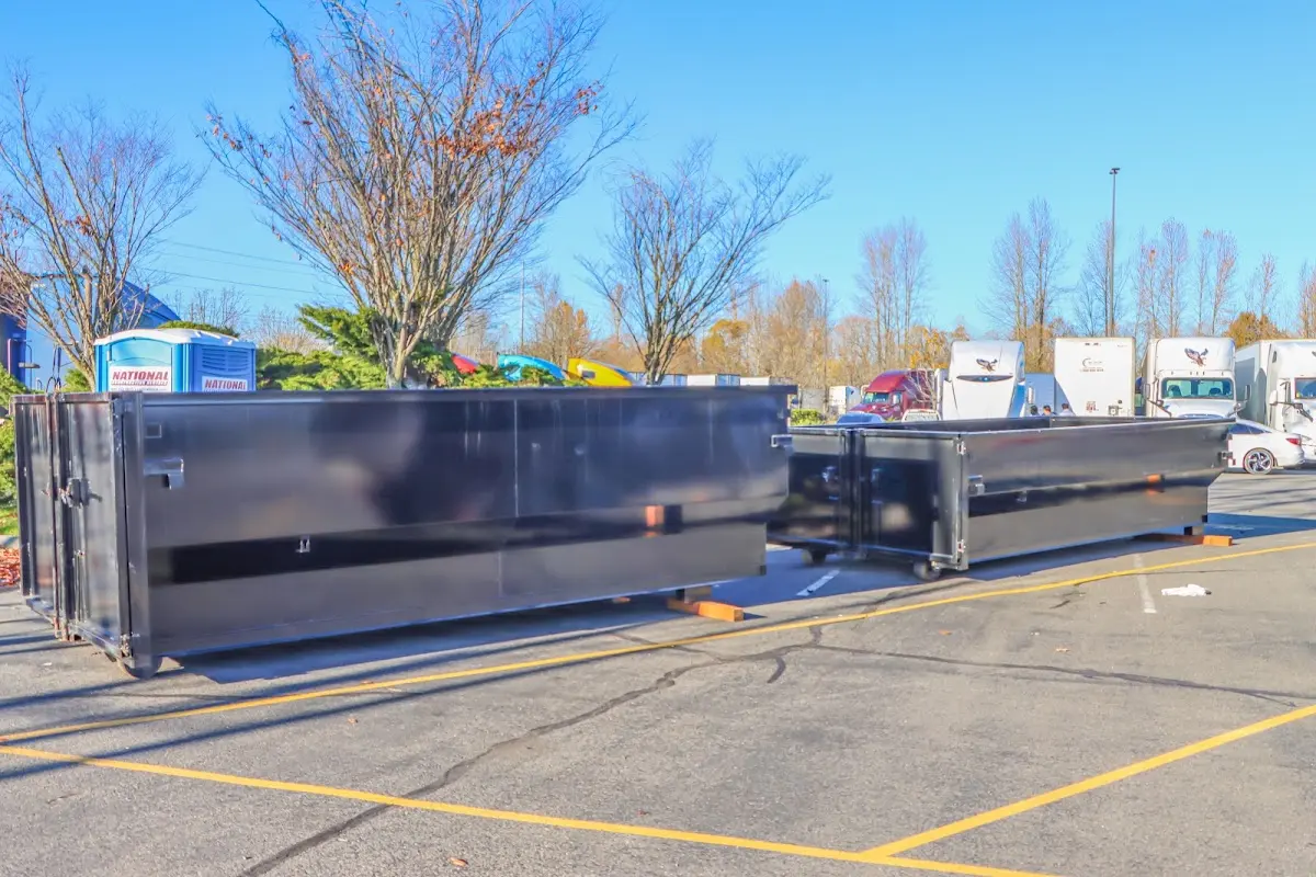 Professional dumpster rental service with roll-off container on residential driveway in Lake of the Woods